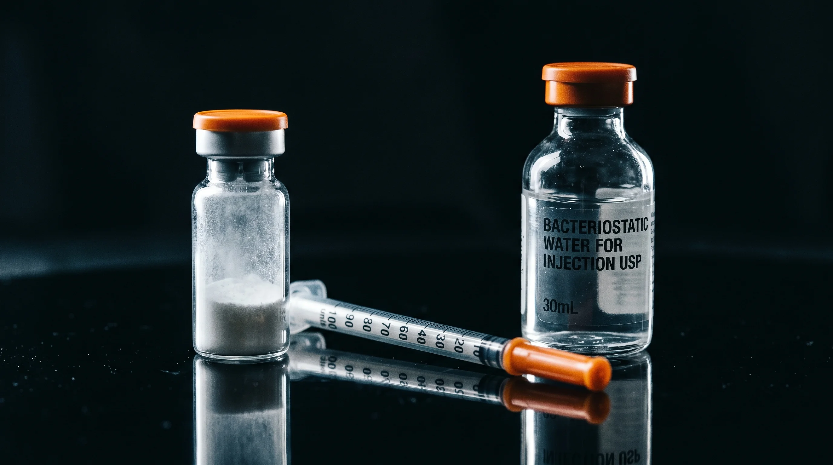 Peptidvial mit Insulinspritze und bakteriostatischem Wasser auf dunkler Oberflaeche, vorbereitet zum Peptide rekonstituieren
